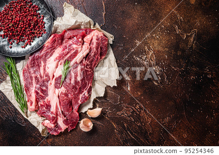 Unccoked marble black angus meat Steak on kitchen table, beef chuck roll steak. Dark background. Unccoked marble black angus meat Steak on kitchen table, beef chuck roll steak. Dark background. 95254346