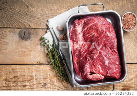 Tri Tip beef steak in steel tray, raw prime meat. Wooden background. Top view. Copy space Tri Tip beef steak in steel tray, raw prime meat. Wooden background. Top view. Copy space 95254353