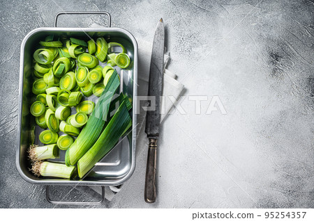 Chopped Green Leek onion with leafs in tray. White background. Top view. Copy space 95254357