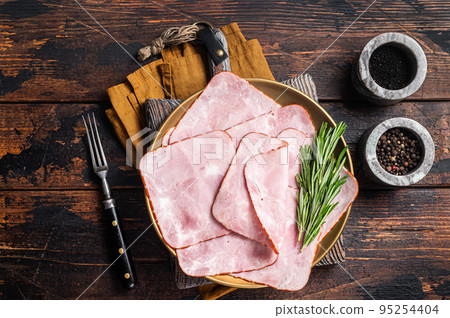 Square Sliced pork meat ham on plate. Wooden background. Top view Square Sliced pork meat ham on plate. Wooden background. Top view 95254404