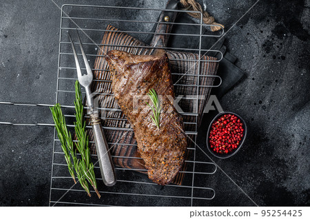 BBQ grilled tri tip beef steak on a grill. Black background. Top view BBQ grilled tri tip beef steak on a grill. Black background. Top view 95254425