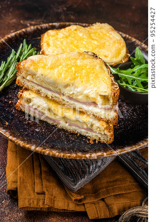 Croque Monsieur toasted sandwich with Cheese, Ham, Gruyere and Bechamel Sauce. Dark background. Top view Croque Monsieur toasted sandwich with Cheese, Ham, Gruyere and Bechamel Sauce. Dark background. Top view 95254427