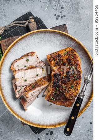 Filipino marinated pork belly with crust in a plate. Gray background. Top view 95254459