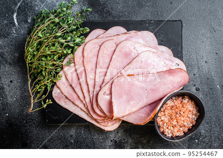 Squared slices of lean pork ham. Black background. Top view Squared slices of lean pork ham. Black background. Top view 95254467