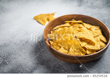 Mexican nachos corn chips in a wooden plate. White background. Top view. Copy space 95254516
