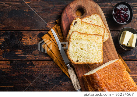 Brioche bread on breakfast table with butter and jam. Wooden background. Top view. Copy space 95254567