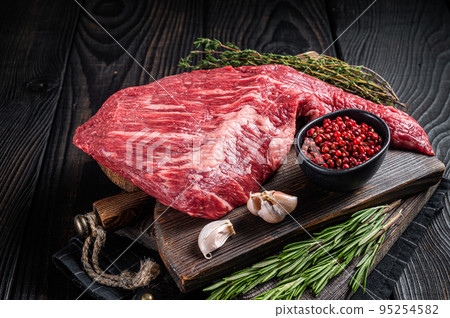 Tri Tip black angus beef steak on cutting board with herbs, raw meat. Black Wooden background. Top view Tri Tip black angus beef steak on cutting board with herbs, raw meat. Black Wooden background. Top view 95254582