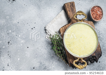 Vichyssoise - traditional French soup made with leek, potato and onion in a pan. Gray background. Top view. Copy space Vichyssoise - traditional French soup made with leek, potato and onion in a pan. Gray background. Top view. Copy space 95254610