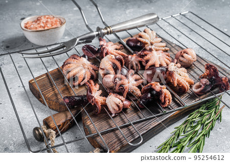 Grilled baby mini octopuses on a grill. Gray background. Top view Grilled baby mini octopuses on a grill. Gray background. Top view 95254612