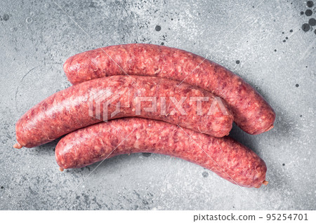 Raw beef meat sausages ready for cooking. Gray background. Top view 95254701