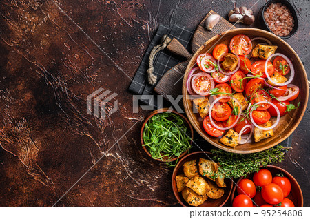 Tuscan Panzanella salad, Vegetarian classic salad with tomatoes, onion and Croutons. Dark background. Top view. Copy space 95254806