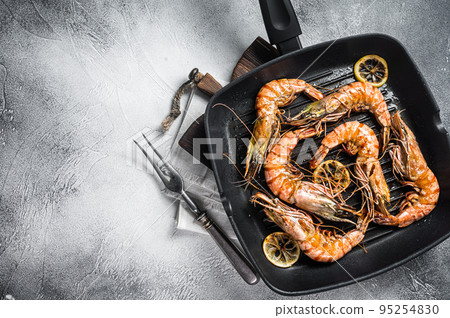 Fried on grill skillet Giant Black tiger prawns shrimps with lemon and herbs. Gray background. Top view. Free copy space Fried on grill skillet Giant Black tiger prawns shrimps with lemon and herbs. Gray background. Top view. Free copy space 95254830