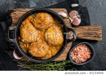 Fish balls with tuna in tomato sauce in a pan. Black background. Top view Fish balls with tuna in tomato sauce in a pan. Black background. Top view 95254940