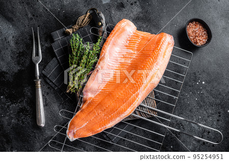 Raw salmon fish fillet, cooking steaks on grill with herbs. Black background. Top view Raw salmon fish fillet, cooking steaks on grill with herbs. Black background. Top view 95254951