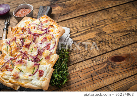 Flammkuchen or tarte flambee with cream cheese, bacon and onions. Wooden background. Top view. Copy space Flammkuchen or tarte flambee with cream cheese, bacon and onions. Wooden background. Top view. Copy space 95254968