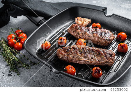 Roasted Lamb tenderloin fillet meat on grill pan, mutton sirloin steak. Gray background. Top view Roasted Lamb tenderloin fillet meat on grill pan, mutton sirloin steak. Gray background. Top view 95255002