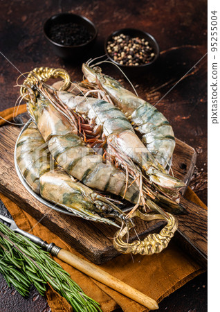 Whole Black tiger giant prawns shrimps in a skillet. Raw Seafood. Dark background. Top view 95255004