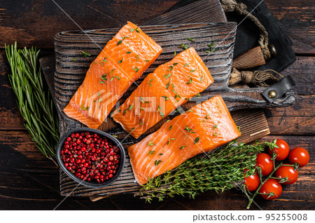 Raw Salmon fillet steaks on wooden board with thyme and rosemary. Wooden background. Top view Raw Salmon fillet steaks on wooden board with thyme and rosemary. Wooden background. Top view 95255008