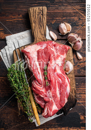 Raw Boneless lamb meat, raw neck meat on wooden board. Black background. Top view 95255012