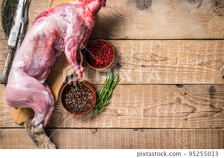 Raw Whole wild hare, fresh game meat on wooden board with herb. Wooden background. Top view. Copy space Raw Whole wild hare, fresh game meat on wooden board with herb. Wooden background. Top view. Copy space 95255013