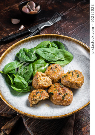 Fish Cakes or Fish balls with tuna and spinach in a plate. Dark background. Top view Fish Cakes or Fish balls with tuna and spinach in a plate. Dark background. Top view 95255028