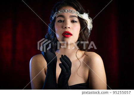 Portrait of old-fashioned brunette woman dressed in style of Gatsby era flirting and posing on 95255057
