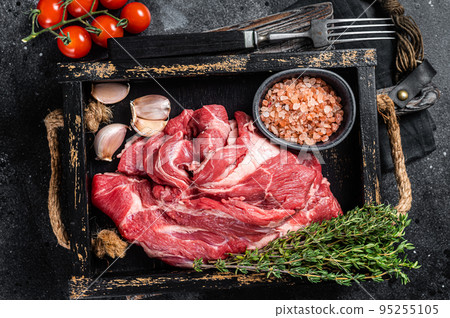 Lamb or mutton neck meat, raw Boneless meat in wooden tray. Black background. Top view Lamb or mutton neck meat, raw Boneless meat in wooden tray. Black background. Top view 95255105