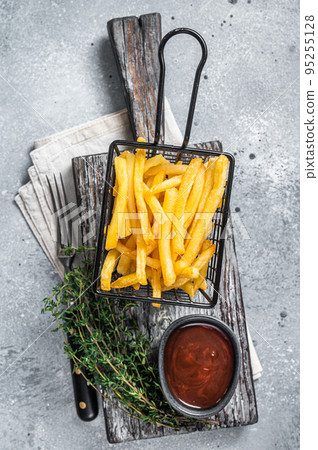 Basket of Fried French fries potatoes with salt on wooden board. Gray background. Top view Basket of Fried French fries potatoes with salt on wooden board. Gray background. Top view 95255128