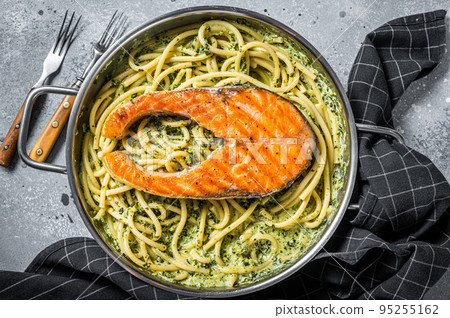 Florentine pasta with creamy spinach sauce and grilled salmon steak. Gray background. Top view 95255162