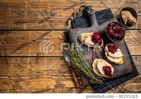 French cuisine Foie gras toasts, goose liver pate and lingonberry marmalade. wooden background. Top view. Copy space 95255163