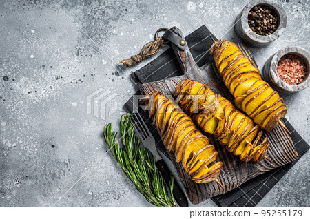 Crispy Tornado or twist potatoes chips on wooden board. Gray background. Top view. Copy space 95255179