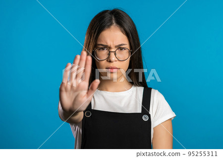 No, never, pretty brunette woman disliking and rejecting gesture by stop sign. Portrait of young 95255311