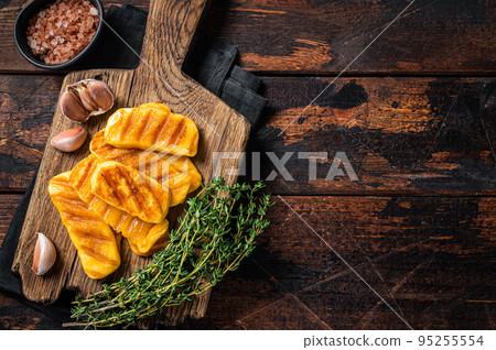 Fried on grill Halloumi cheese with herbs and thyme. Wooden background. Top view. Copy space 95255554
