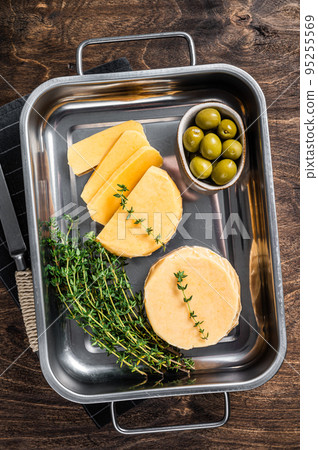 Fresh Halloumi sliced cheese in kitchen tray with thyme. Wooden background. Top view 95255569
