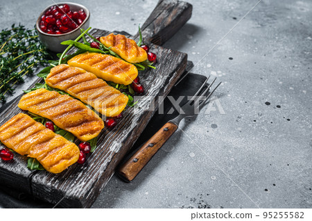 BBQ Grilled Halloumi cheese with arugula on wooden board. Gray background. Top view. Copy space 95255582