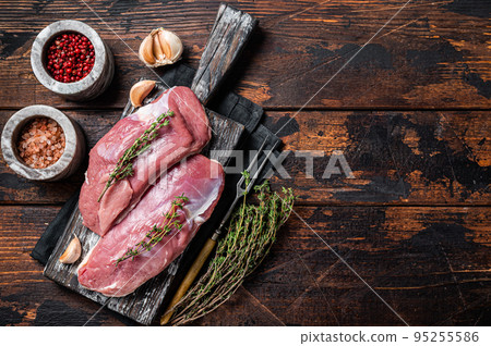 Raw Duck breasts, poultry meat steaks on wooden board ready for cooking. Wooden background. Top view. Copy space 95255586