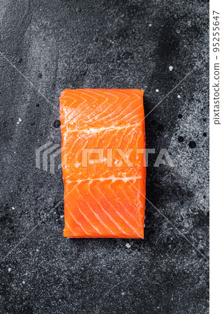 Raw salmon fillet steaks on kitchen table. Black background. Top view 95255647