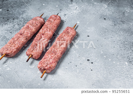 Raw Turkish Adana shish kebab on butcher table. Gray background. top view. Copy space Raw Turkish Adana shish kebab on butcher table. Gray background. top view. Copy space 95255651