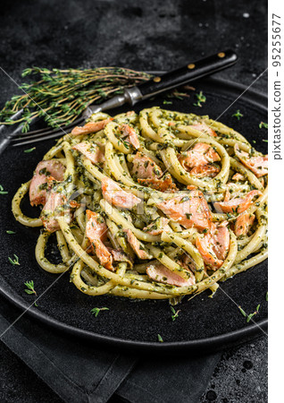 Bucatini Pasta with Smoked Salmon fillet and creamy spinach. Black background. Top view Bucatini Pasta with Smoked Salmon fillet and creamy spinach. Black background. Top view 95255677