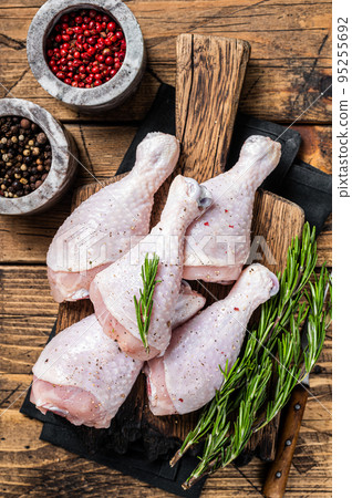 Fresh Chicken drumsticks legs with skin, raw poultry meat. Wooden background. Top view 95255692