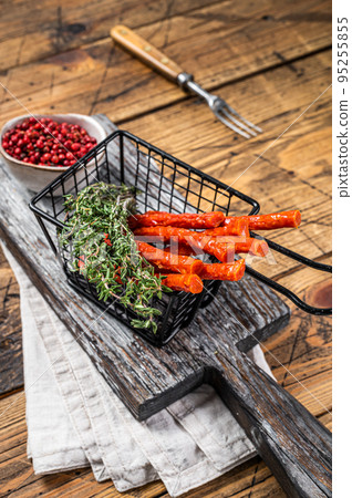 Homemade small thin kabanos sausages in a basket. Wooden background. Top view 95255855