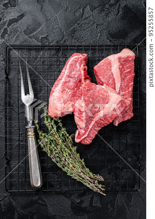 Topside sirloin beef cut, raw meat with spices. Black background. Top view 95255857