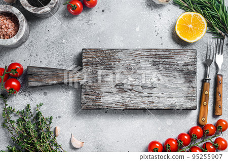 Food cooking and healthy eating background with wooden cutting board and fresh seasoning, herbs and vegetables. Gray background. Top view. Copy space 95255907