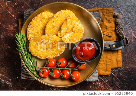 Roast Hash brown potato, Vegetable fritters in a plate with tomato sauce. Dark background. Top view 95255940