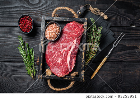 Unccoked rump steak or raw top sirloin beef meat steak. Black wooden background. Top view Unccoked rump steak or raw top sirloin beef meat steak. Black wooden background. Top view 95255951