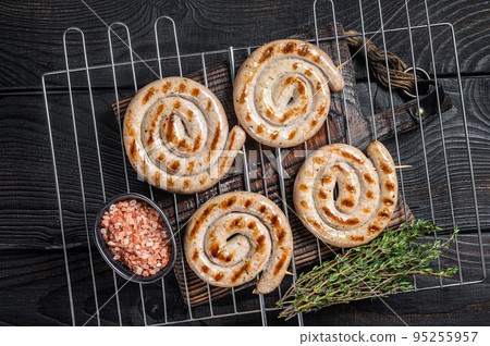 BBQ grilled spiral pork meat sausages on a grill. Black background. Top view BBQ grilled spiral pork meat sausages on a grill. Black background. Top view 95255957