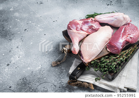 Butchered whole duck, raw breast steak, legs, wings on a butcher cutting board. Gray background. Top view. Copy space Butchered whole duck, raw breast steak, legs, wings on a butcher cutting board. Gray background. Top view. Copy space 95255991