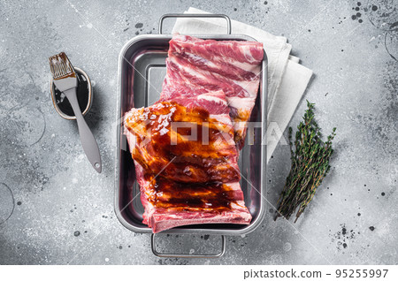 Cooking of Raw pork spare ribs with barbecue sauce. Gray background. Top view Cooking of Raw pork spare ribs with barbecue sauce. Gray background. Top view 95255997