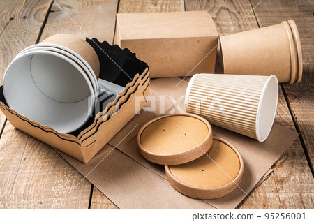 Disposable paper tableware. Eco friendly Recycling set of paper cups, dishes, bag, fast food containers and cutlery. Wooden background. Top view. Copy space Disposable paper tableware. Eco friendly Recycling set of paper cups, dishes, bag, fast food containers and cutlery. Wooden background. Top view. Copy space 95256001