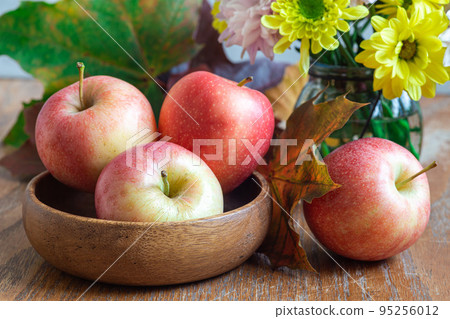 Autumn season or Thanksgiving holiday concept with apples, flowers and fall leaves, horizontal 95256012